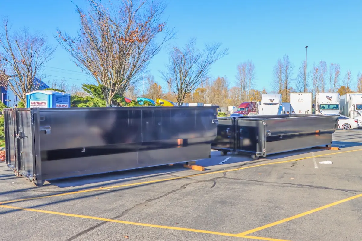 Professional dumpster rental service with roll-off container on residential driveway in Center Point